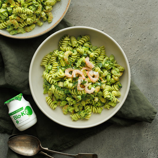 2 pasta and shrimp salad bowls with a Bio-K+ bottle