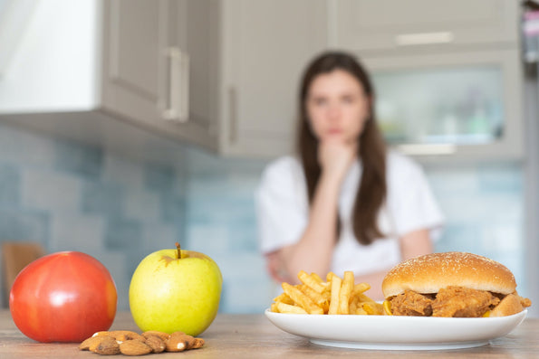 Burger with on the side an apple and a tomato
